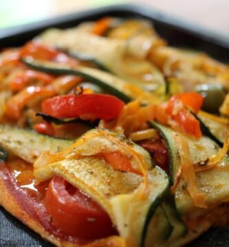 deliciosa pizza vegetariana es una opción perfecta para una comida ligera y saludable. Con una base crujiente y una combinación de verduras frescas y sabrosas, ¡esta pizza casera te conquistará! 'Pizza casera con base delgada, cubierta con salsa de tomate, rodajas de calabacín, pimiento rojo y aceitunas negras